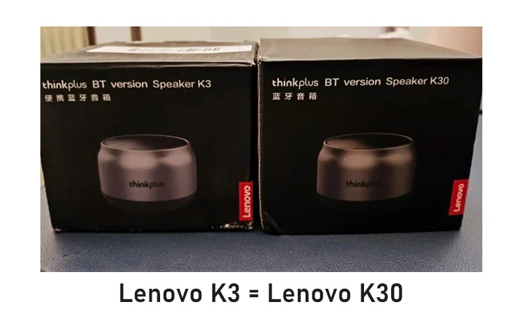 Two black boxes each featuring a sleek, round, metallic grey portable wireless speaker.