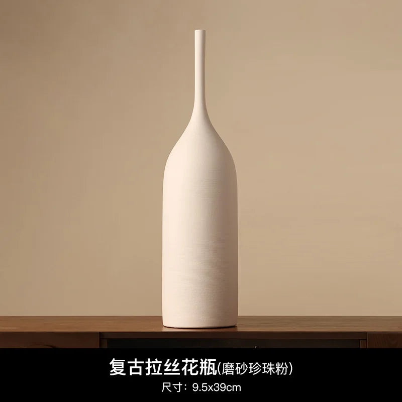 Tall, slim, matte cream ceramic vase with a minimalist wabi-sabi design and a subtly textured finish.