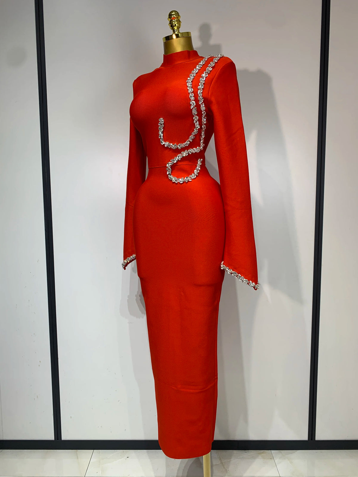 Red long-sleeve bodycon maxi dress featuring a high neckline and sparkling rhinestone embellishments.