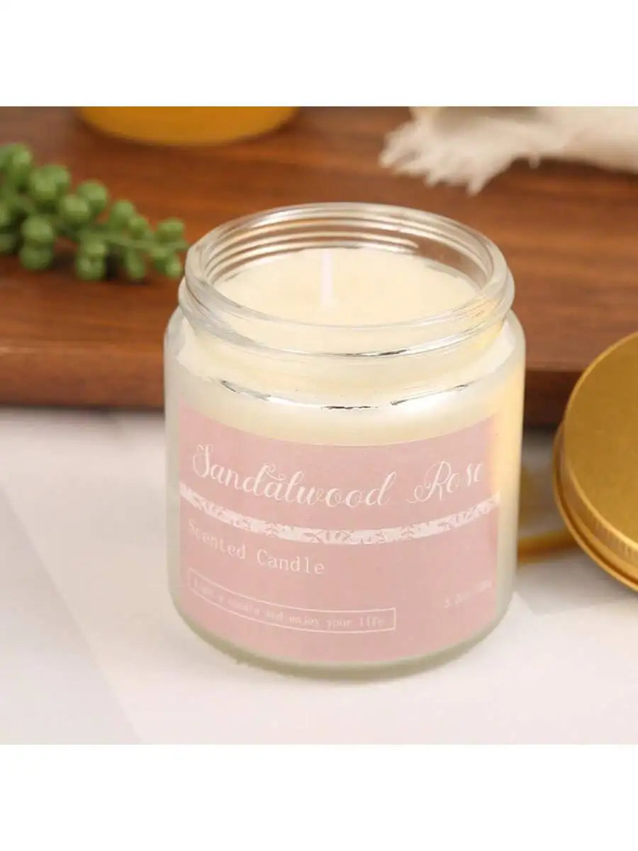 Sandalwood Rose scented candle in a glass jar with a soft pink label and gold-tone lid.
