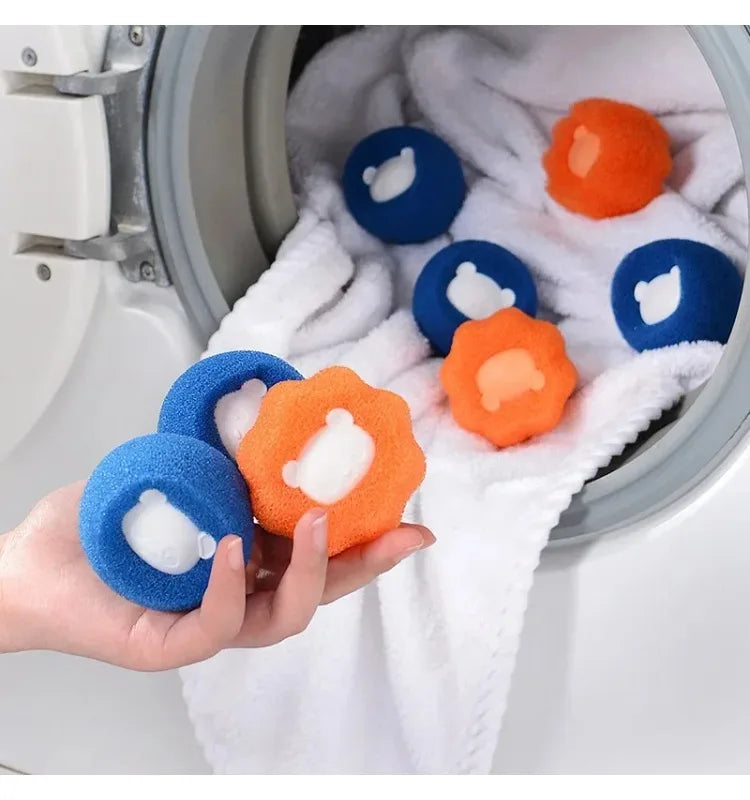 Hand holding blue and orange patterned laundry sponge balls in front of a washing machine filled with white fabric.