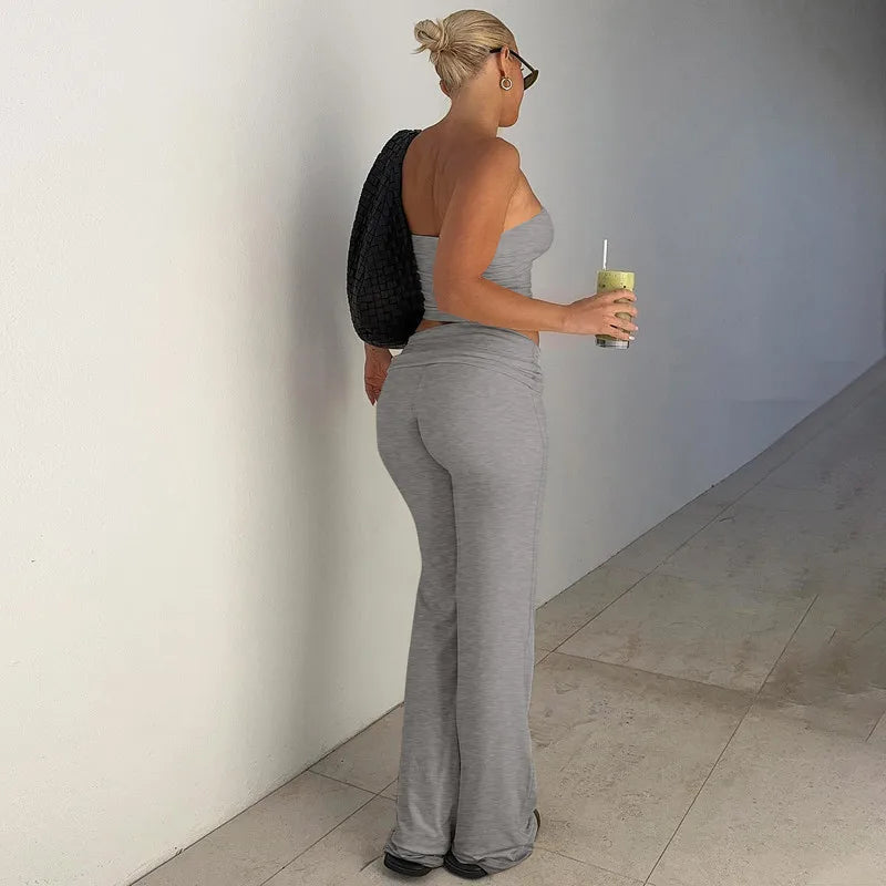 Grey two-piece set featuring a strapless crop top and matching high-waisted, flared jersey leggings.