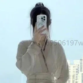 A woman in a cream-coloured traditional-style wrap top with long sleeves and a V-neck, seen in a mirror selfie.