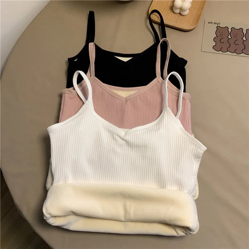 Three sleeveless ribbed camisoles in white, pink, and black, featuring a V-neckline and a warm, soft fleece lining.