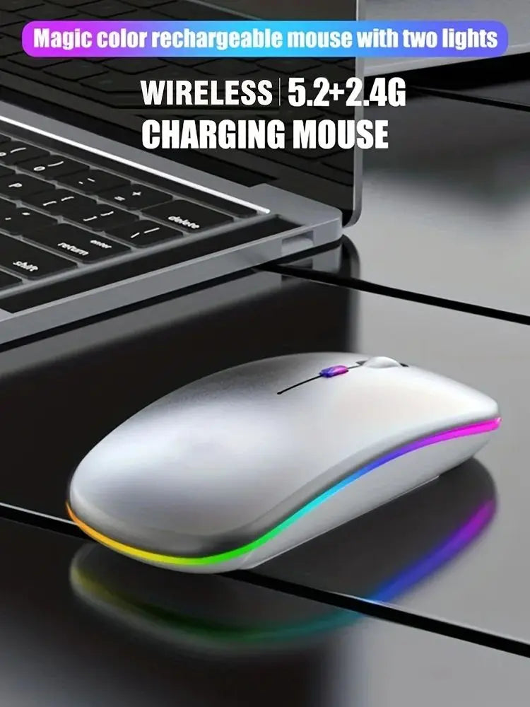 Sleek silver wireless rechargeable mouse with vibrant LED edge lighting on a desk next to a laptop.