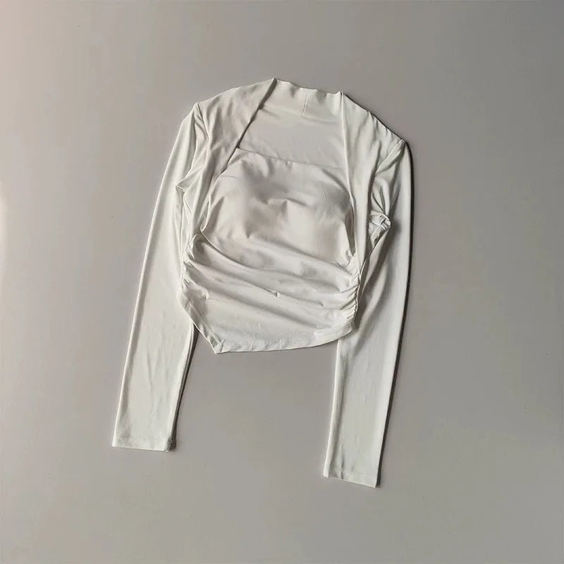 White long-sleeve crop top with a square neckline, integrated bust detail, and ruched side panels.