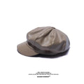 Beige faux leather baker boy cap with a structured peak, panelled design, and a retro aesthetic.