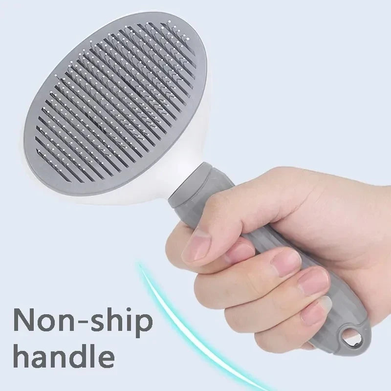 Hand holding a grey and white pet slicker brush with a textured non-slip handle.