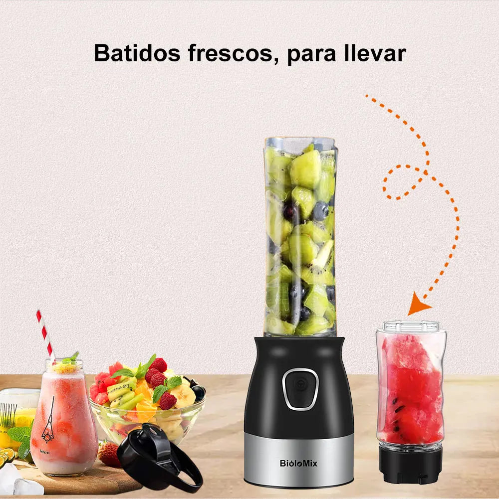 Portable blender with a black and silver base, including a transparent bottle filled with chopped kiwi and fruit pieces.