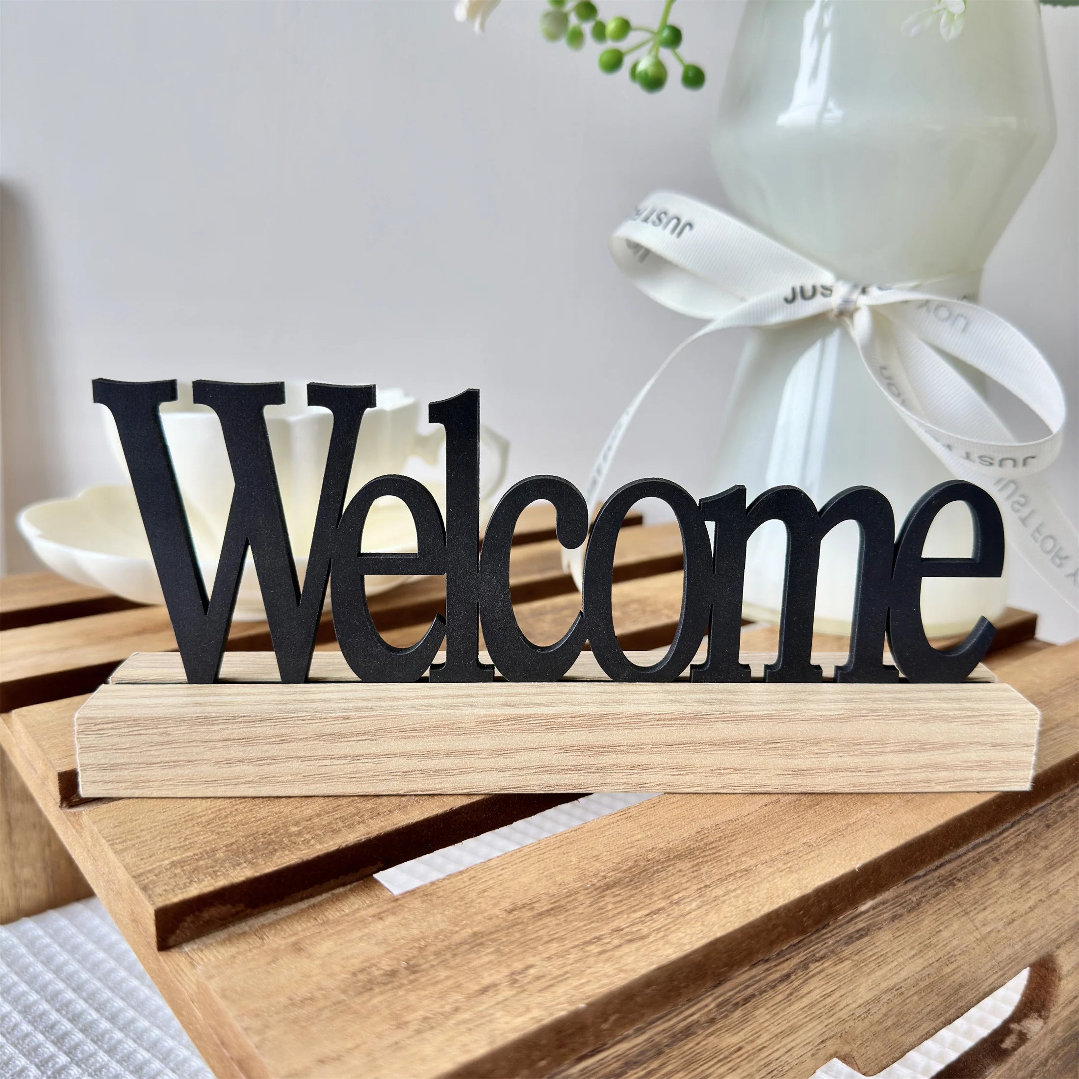 Rustic 'Welcome' sign featuring black wooden lettering on a natural light wood base.