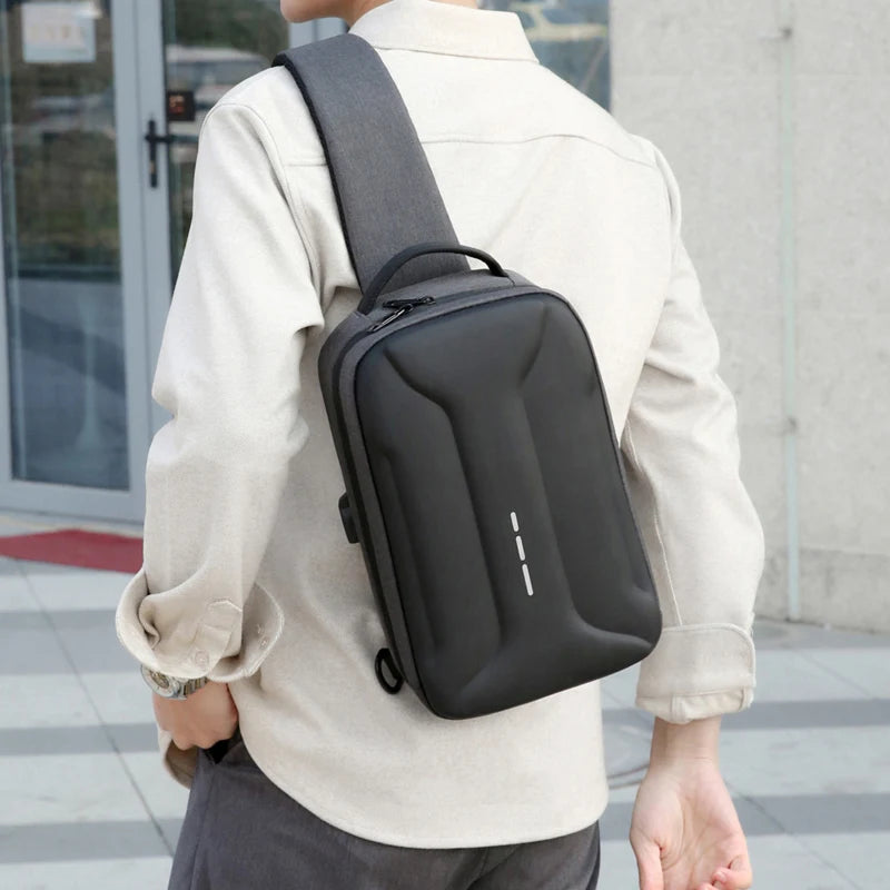A man wearing a sleek, black anti-theft crossbody bag with a built-in USB charging port and minimalist design.