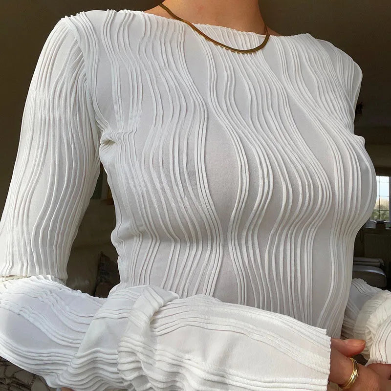 White long-sleeved top with a slim fit, round neck, and vertical rippled, textured wave detailing throughout.