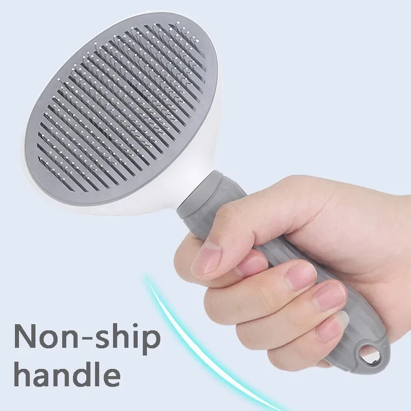 A hand holding a white and grey pet grooming slicker brush with thin metal bristles and a textured non-slip handle.