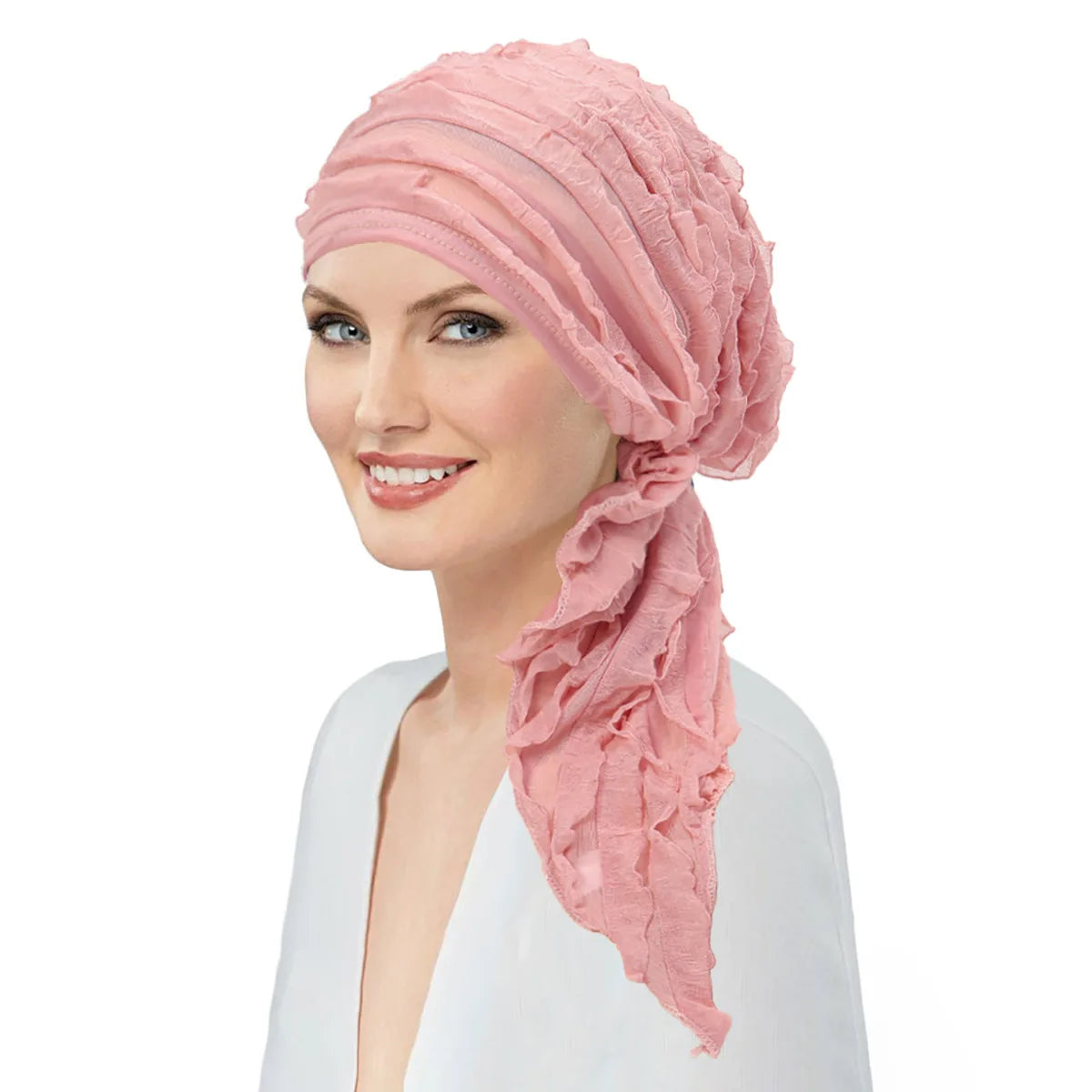 A woman wearing a dusty pink, pre-tied ruffle turban head wrap with an elegant side drape.