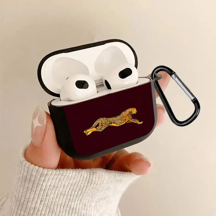 Dark maroon silicone AirPods 3 case featuring a running cheetah print and black carabiner, held in hand.