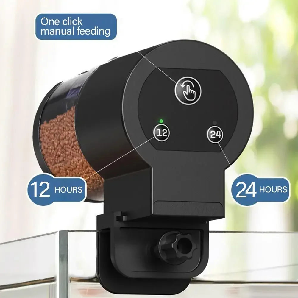 Black automatic aquarium fish feeder with a transparent food container, manual feed button, and 12/24-hour timer settings.