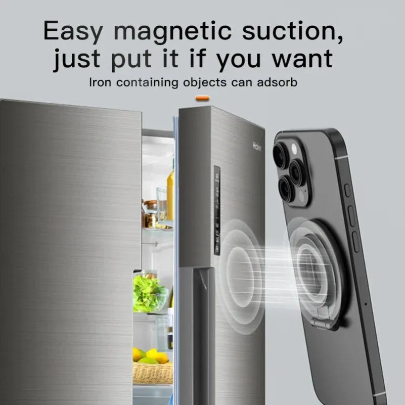 A grey magnetic ring mount attaching a dark grey smartphone to the metal door of a stainless steel fridge.