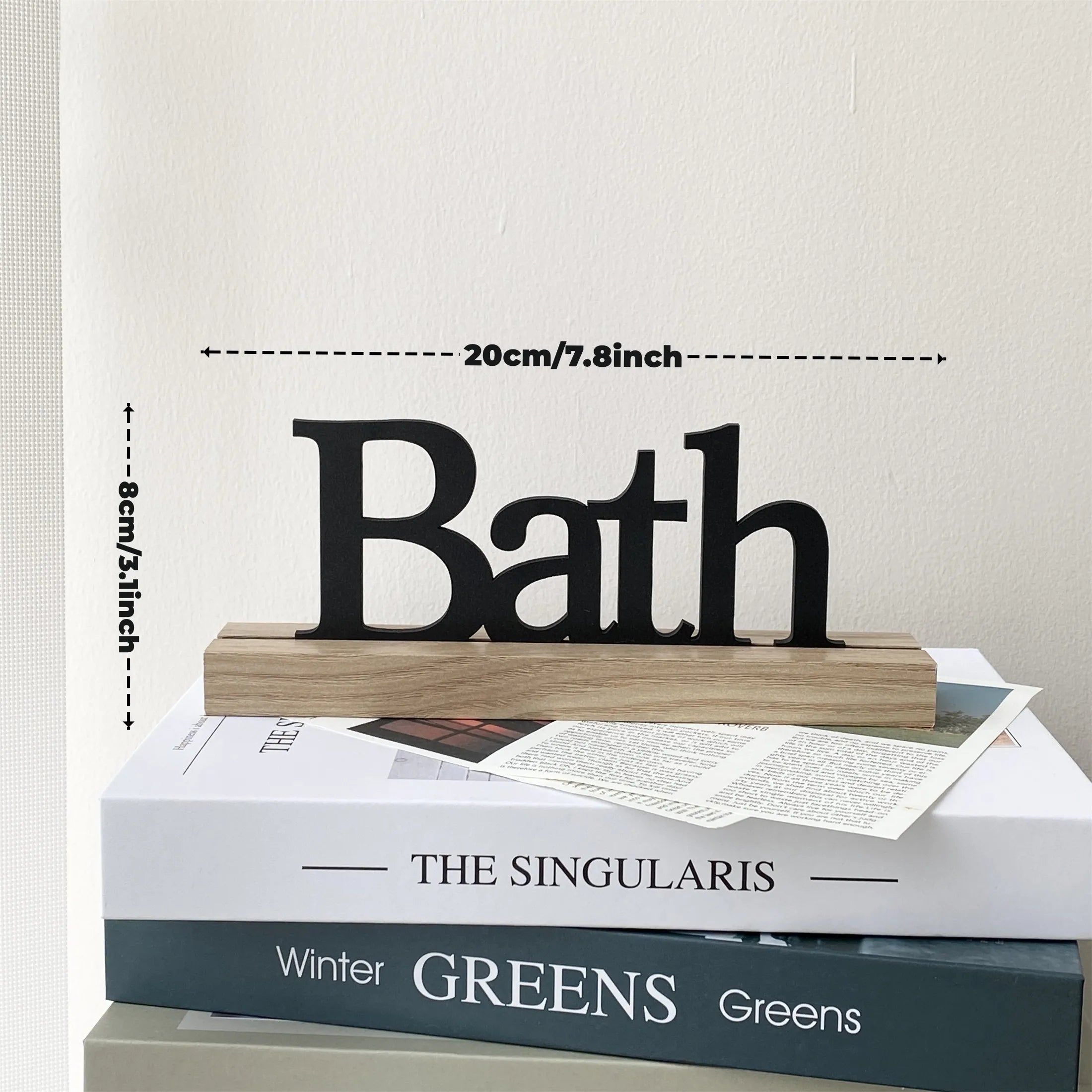 Freestanding wooden block sign with black 'Bath' lettering, measuring 20cm by 8cm, displayed on decorative books.