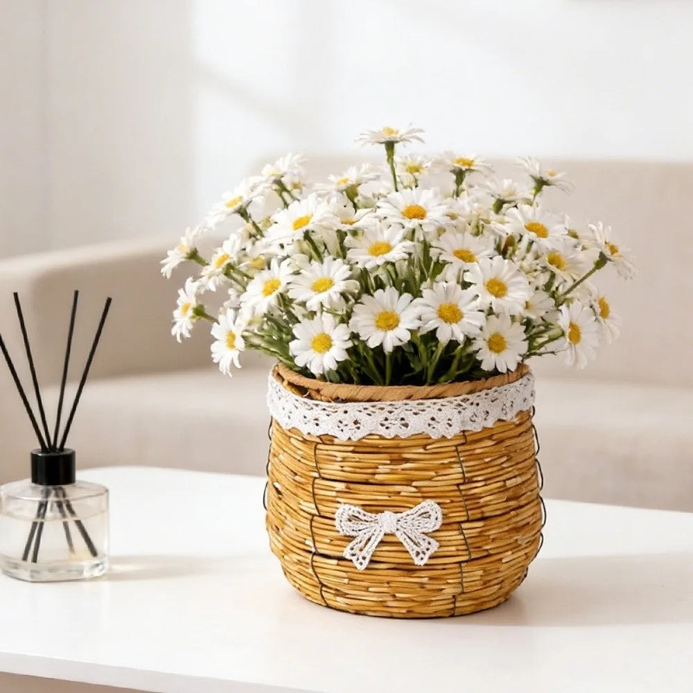 A woven tan plastic basket with a white lace trim and bow, filled with a lush bouquet of white daisy flowers.