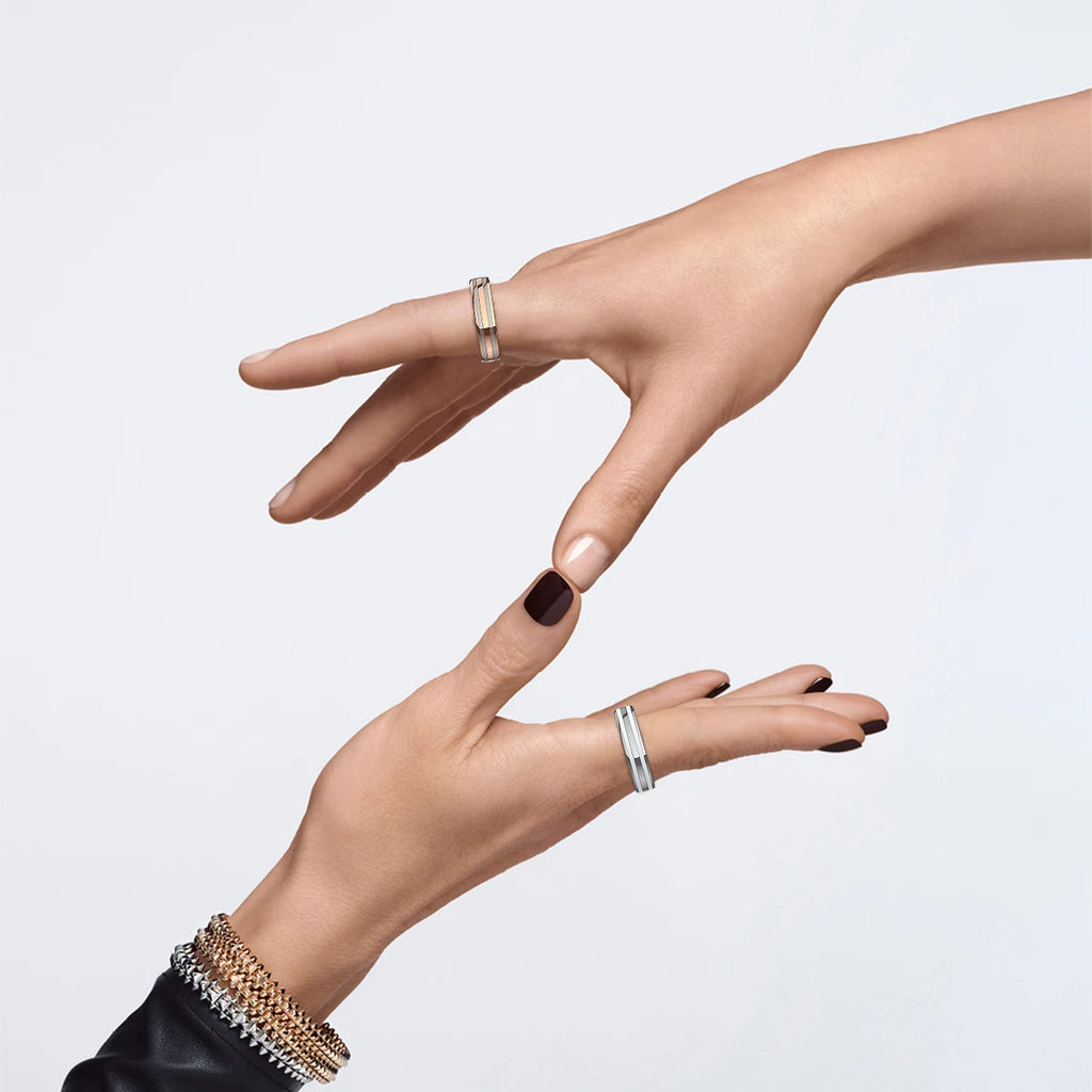 Two hands wearing sleek, metallic smart fitness rings in silver and rose gold tones, forming a Z shape against white.