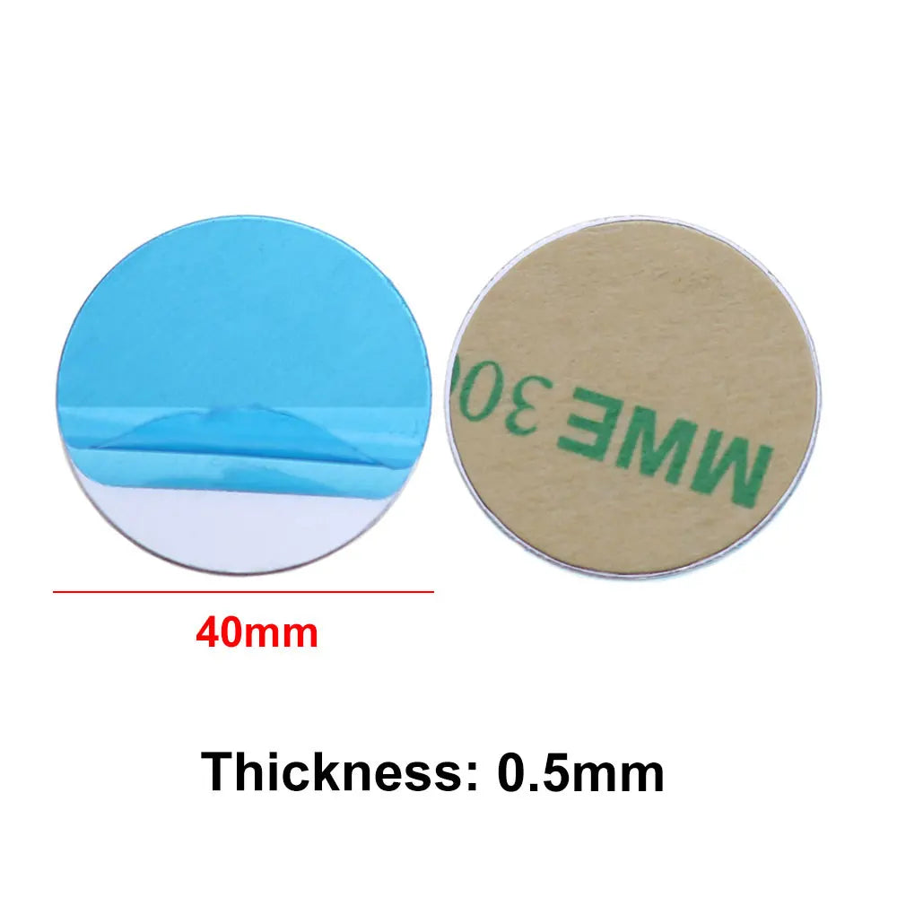 Two 40mm round adhesive metal discs, one with a blue protective film, the other with a tan backing. 0.5mm thickness.