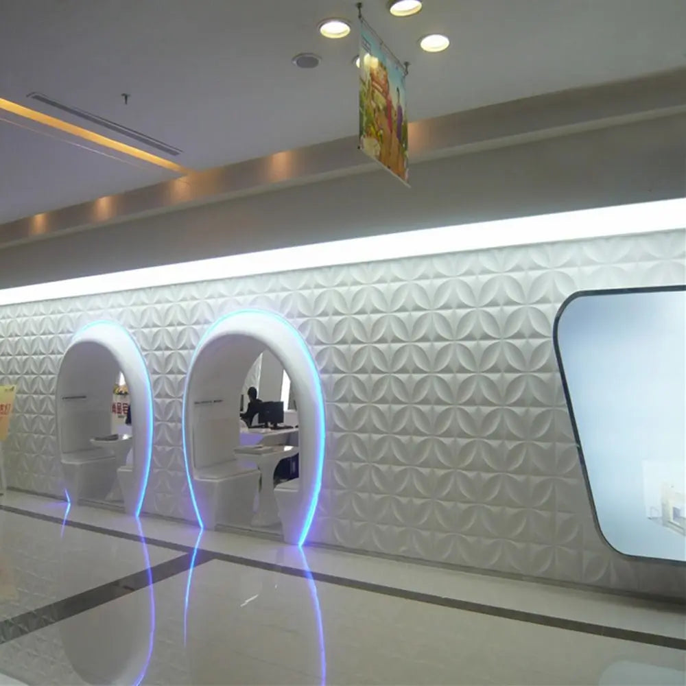 White 3D decorative wall panels with a repeating diamond design in a modern, illuminated commercial interior.