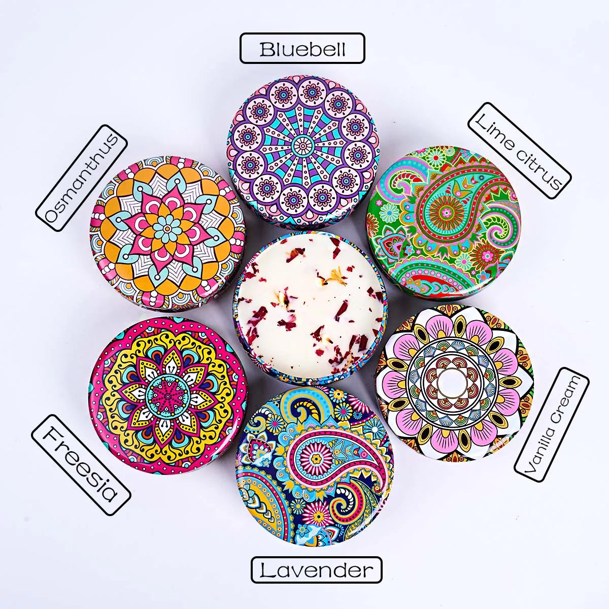 Six round, colourful tins featuring intricate mandala and paisley patterns, surrounding an open scented candle.