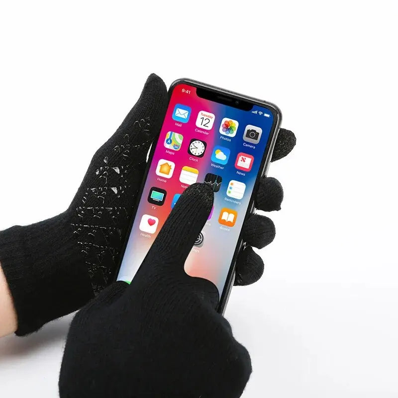Close-up of a person wearing black touchscreen-compatible knit gloves while using a smartphone.