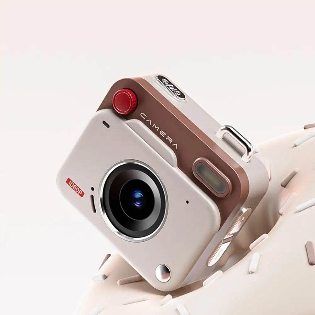 Small beige and brown digital camera with a red shutter button, silver accents, and a 1080p lens.