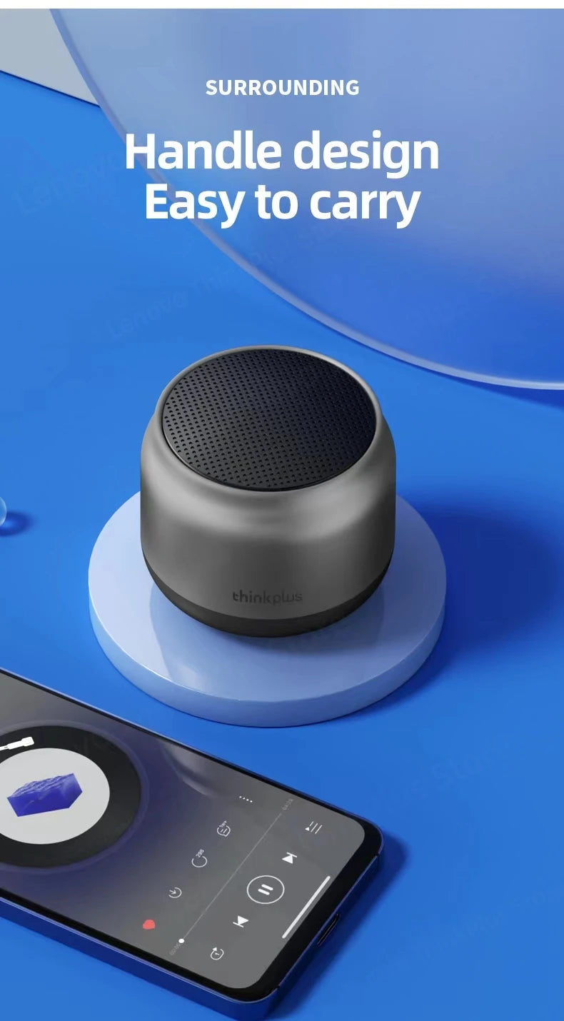 A compact, dark grey cylindrical portable Bluetooth speaker with a metallic finish, displayed on a blue background.