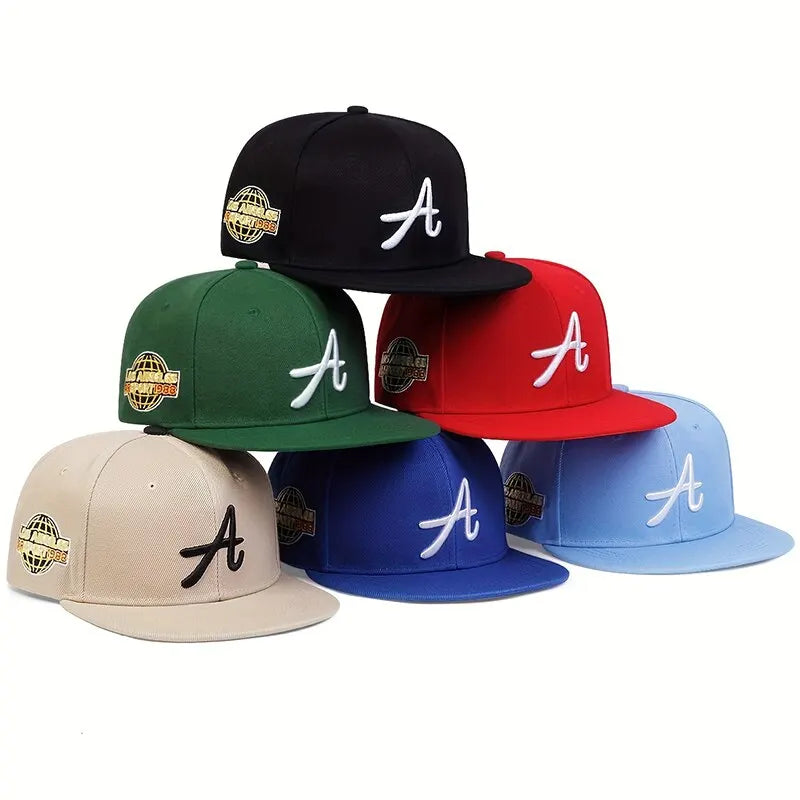 A stack of unisex hip-hop baseball caps in various colours, featuring an embroidered 'A' and globe side patch.