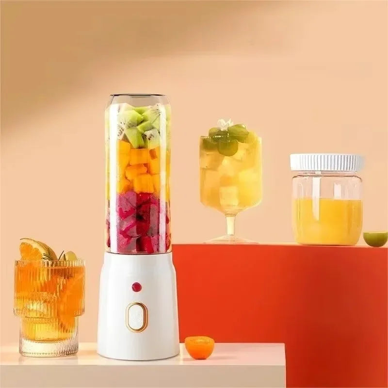 A white portable blender filled with layered fruit next to glassware on a peach-coloured background.