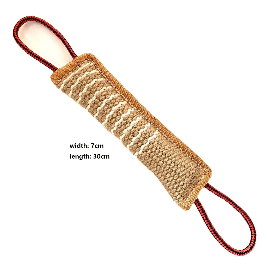 Tan jute dog bite tug with white stitching and red and black rope handles on each end, measuring 30cm by 7cm.
