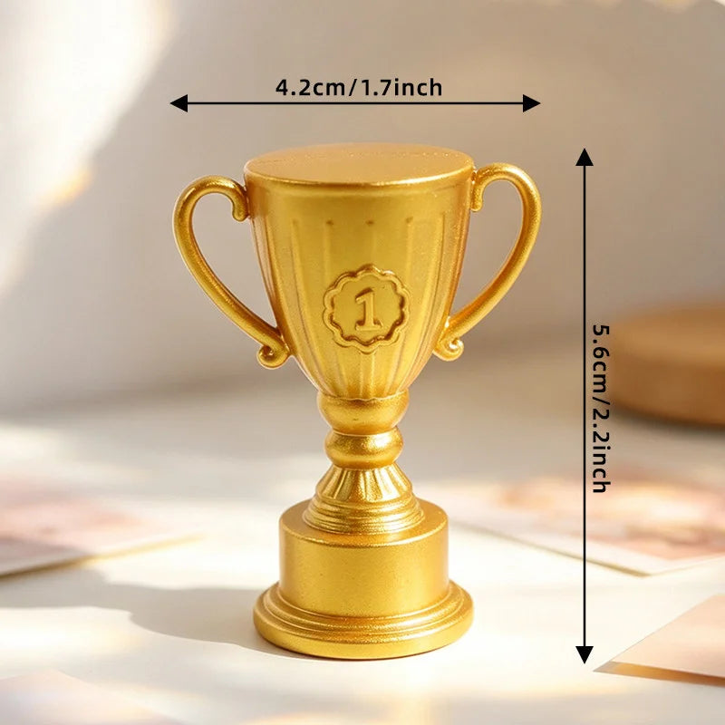 Small gold-coloured trophy featuring a '1' emblem, measuring 4.2cm wide by 5.6cm high.