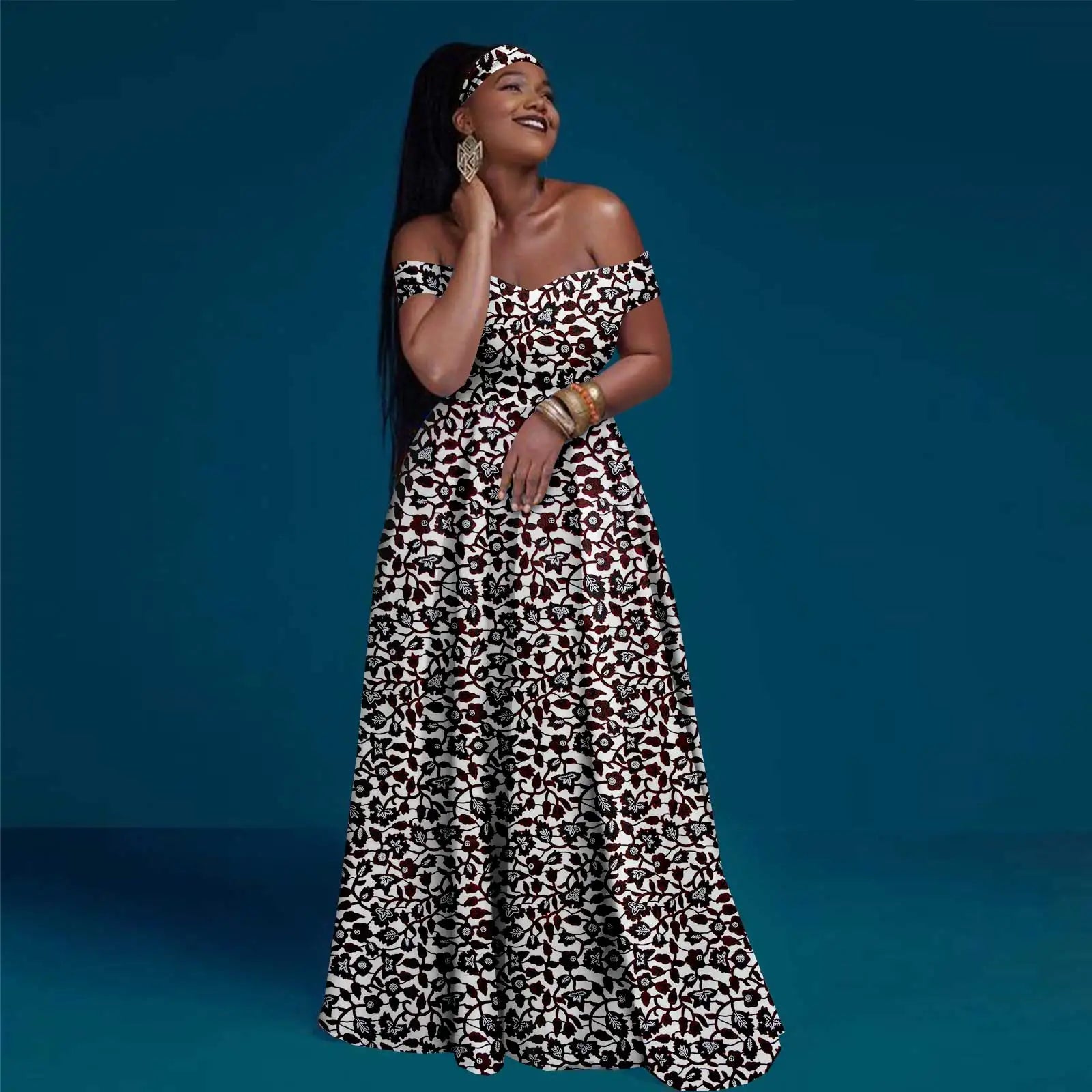 Woman wearing an off-the-shoulder, floor-length maxi dress with a black and white floral print and matching headband.