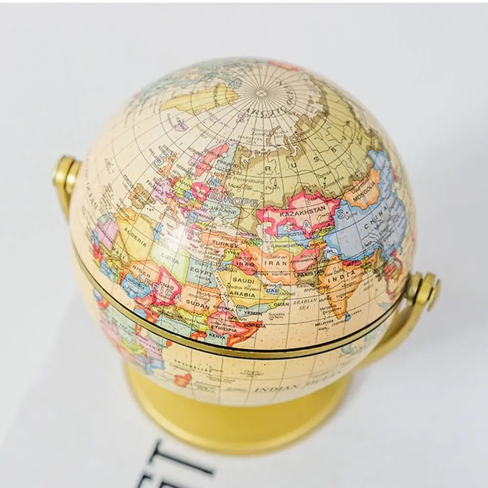Vintage-style world globe in muted earth tones on a brushed gold stand, featuring detailed political map markings.