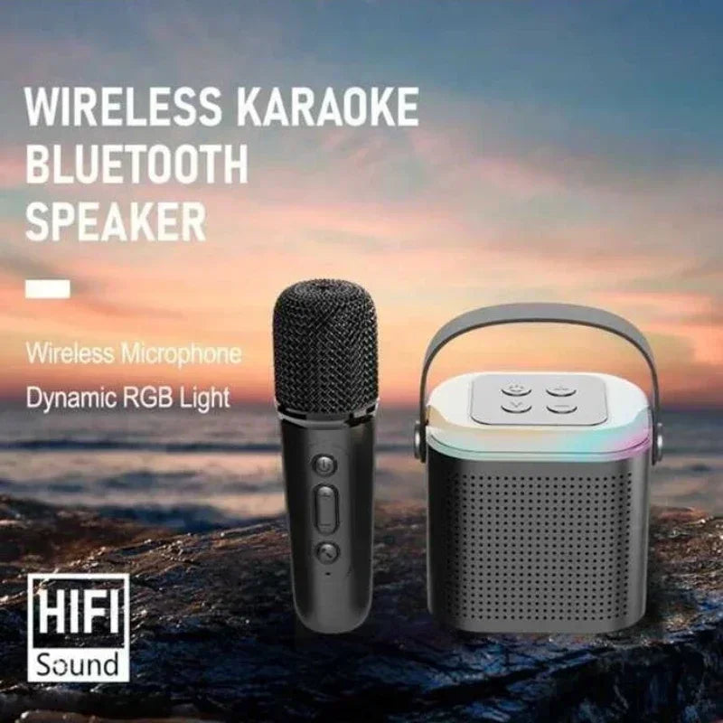 Black wireless karaoke speaker with handle, microphone, and colourful RGB light base on a rocky beach backdrop.