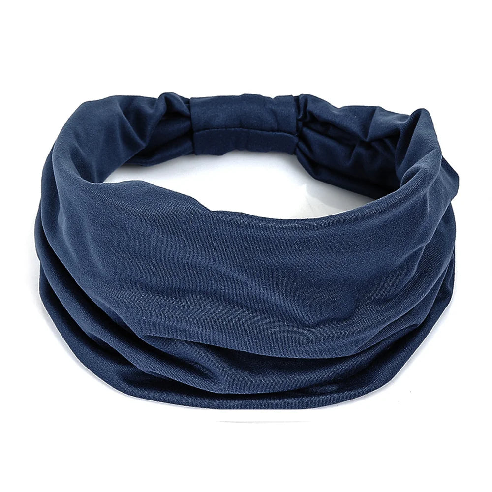 A plain navy blue, wide fabric headband with a gathered elastic back section.