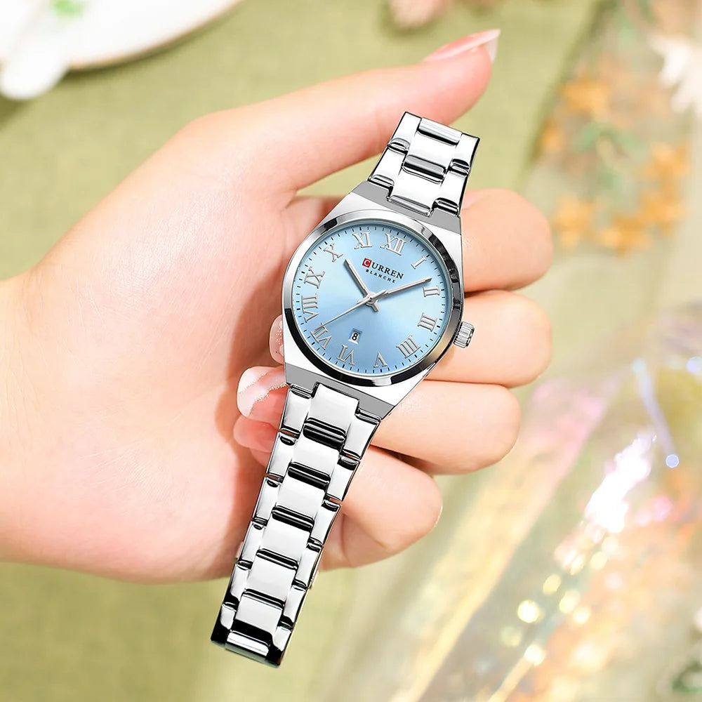 CURREN women's quartz wristwatch with a round light blue face, Roman numerals, and a silver stainless steel link strap.