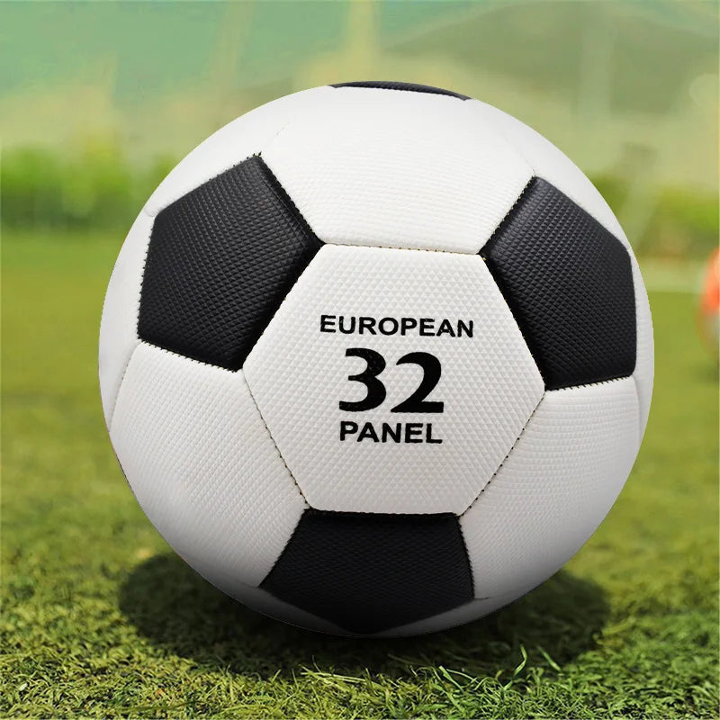 Classic black and white 32-panel football on a green grass field.