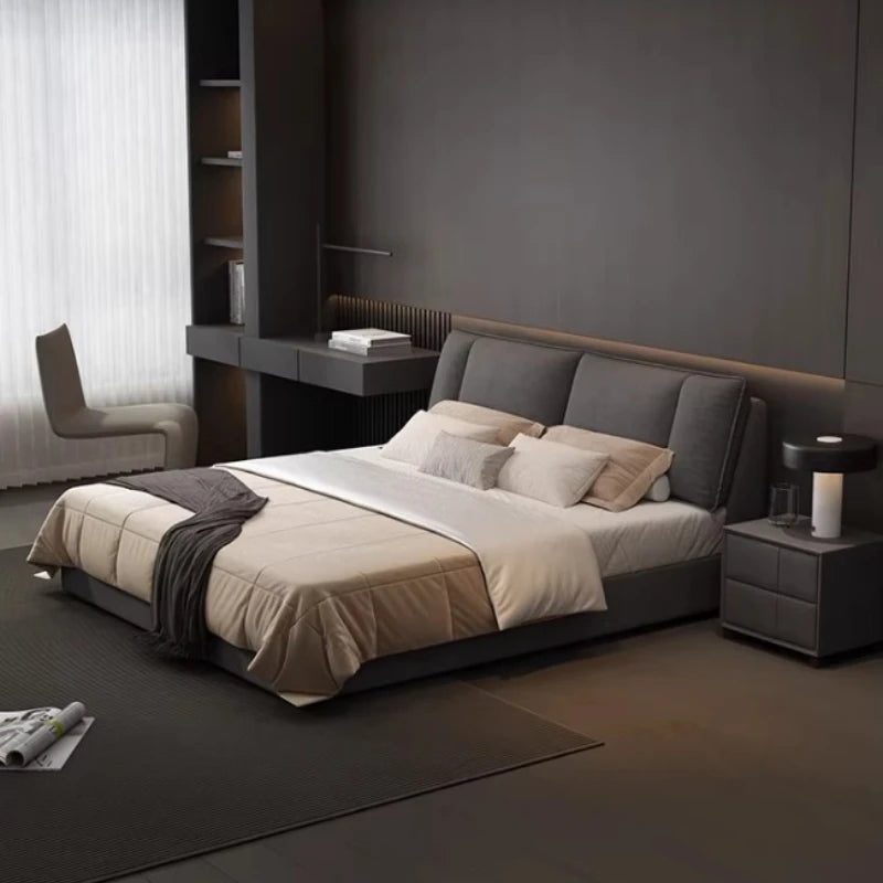 Modern dark grey upholstered double bed with a cushioned headboard and sleek, minimalist design in a contemporary room.