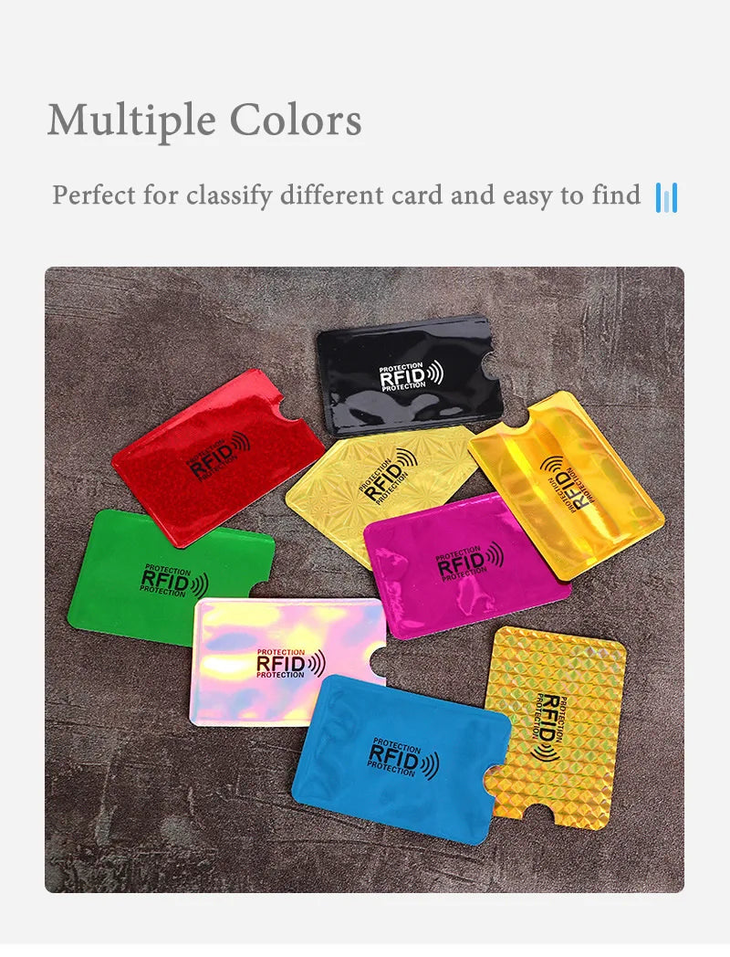 Multi-colored RFID-blocking plastic card protector sleeves with thumb slots, scattered on a grey surface.