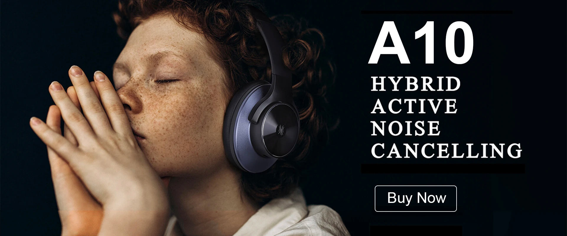 A person wearing sleek, dark grey over-ear noise-cancelling headphones against a black background.