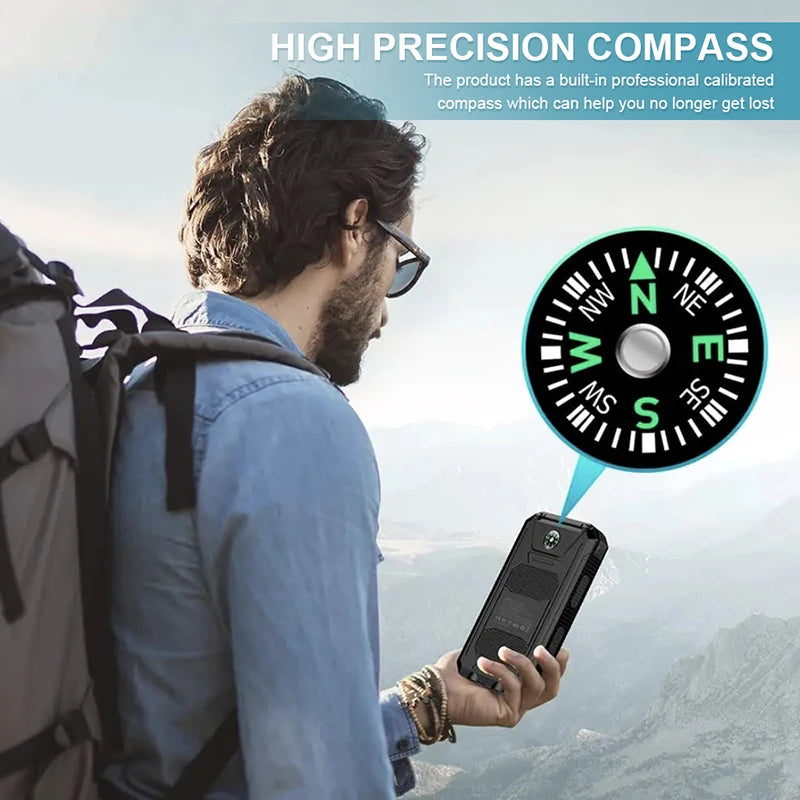 Black rugged 80000mAh solar power bank with a built-in precision compass, held by a hiker against a mountain backdrop.