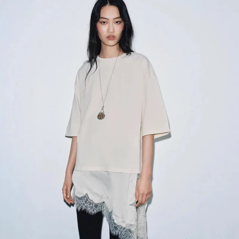 Cream oversized t-shirt with elbow-length sleeves and a delicate, asymmetrical white lace hem detail.