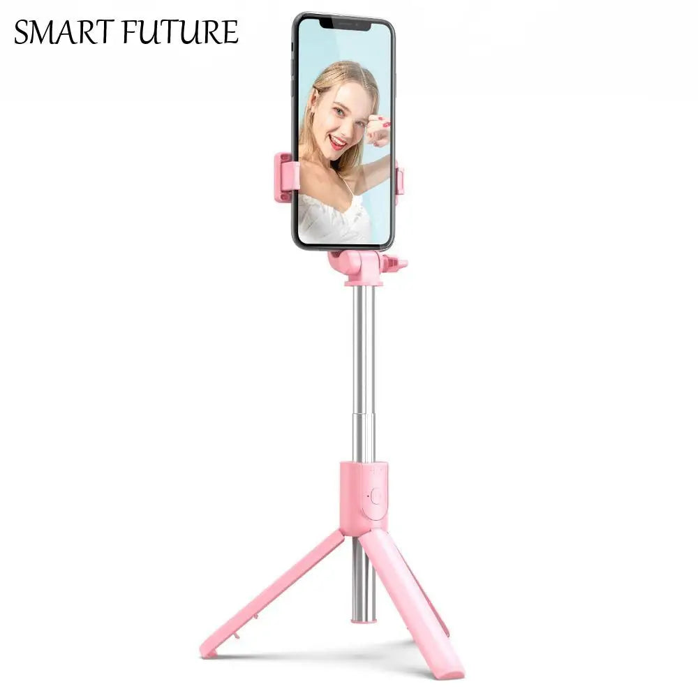 Pastel pink adjustable smartphone tripod selfie stick with an extendable silver pole and integrated phone holder.