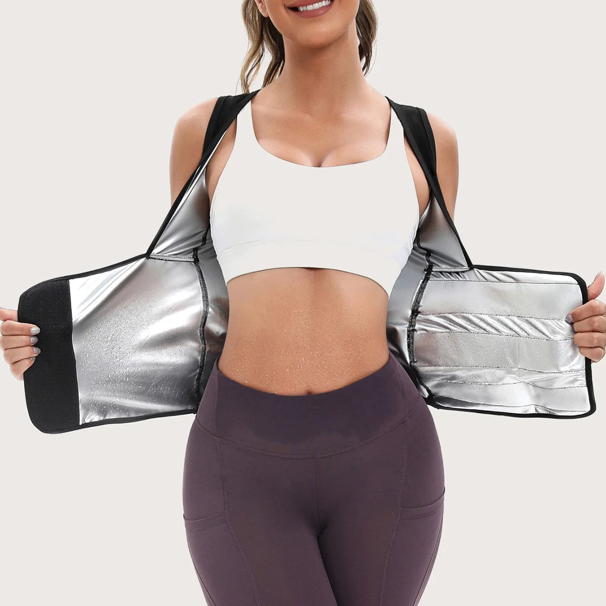 Black waist-shaping vest with a silver metallic thermal lining, worn open to show the sweat-inducing interior.