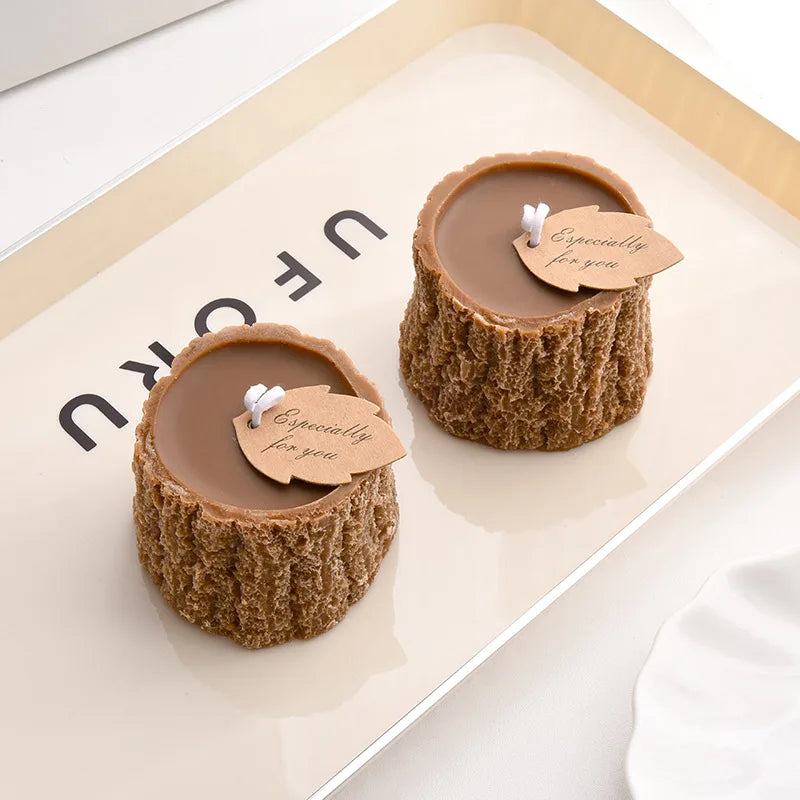 Two brown tree stump-style candles with "Especially for you" leaf tags, displayed on a cream tray.