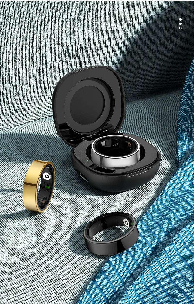 Gold and black health-monitoring smart rings displayed with an open charging case on a textured blue fabric surface.