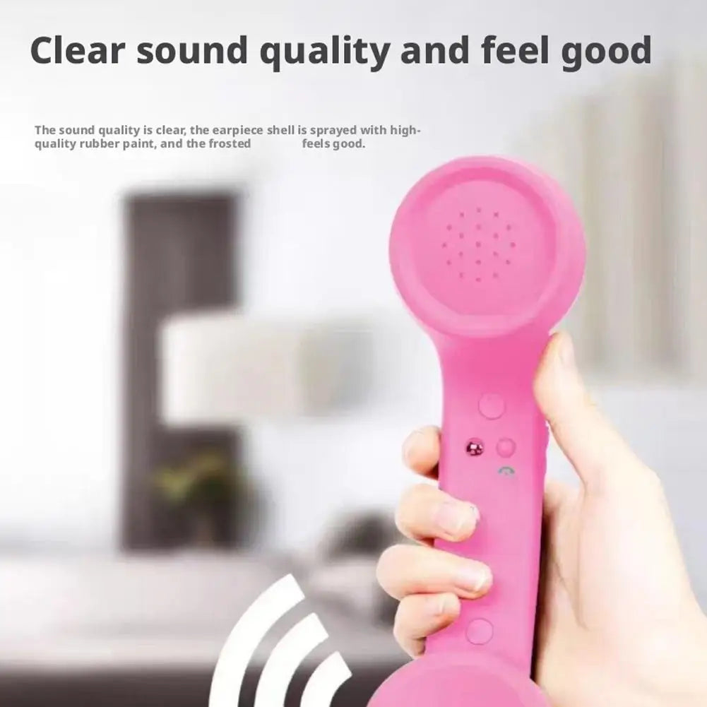 A hand holding a pink, retro-style telephone handset with a soft-touch, matte frosted finish.